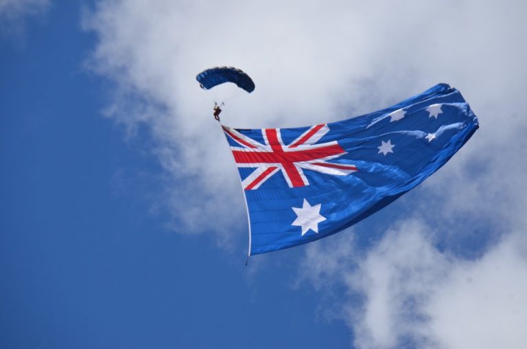 Australia Quiz Questions and Answers - Australian Trivia Questions header image of a skydiver parachuting down trailing a huge Australian flag