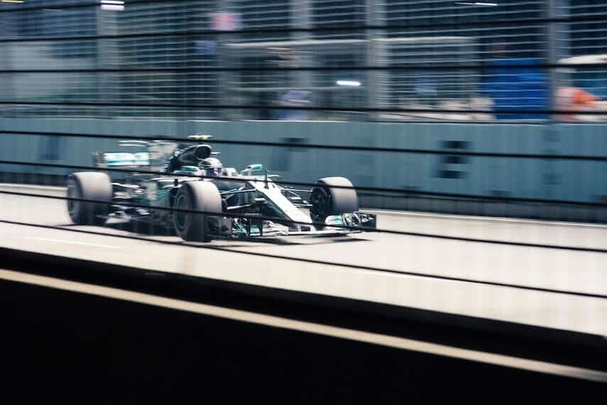 F1 car whizzing past the pit lane