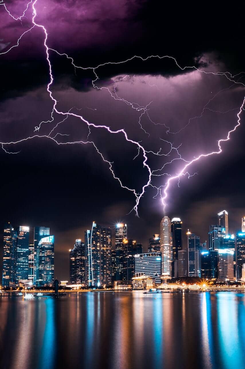 Silver Lightning above a city skyline under a deep purple sky