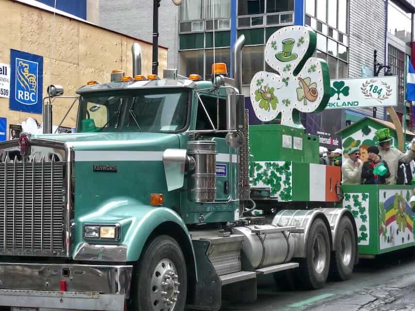 Green truck towing a St Patricks Day Parade Float