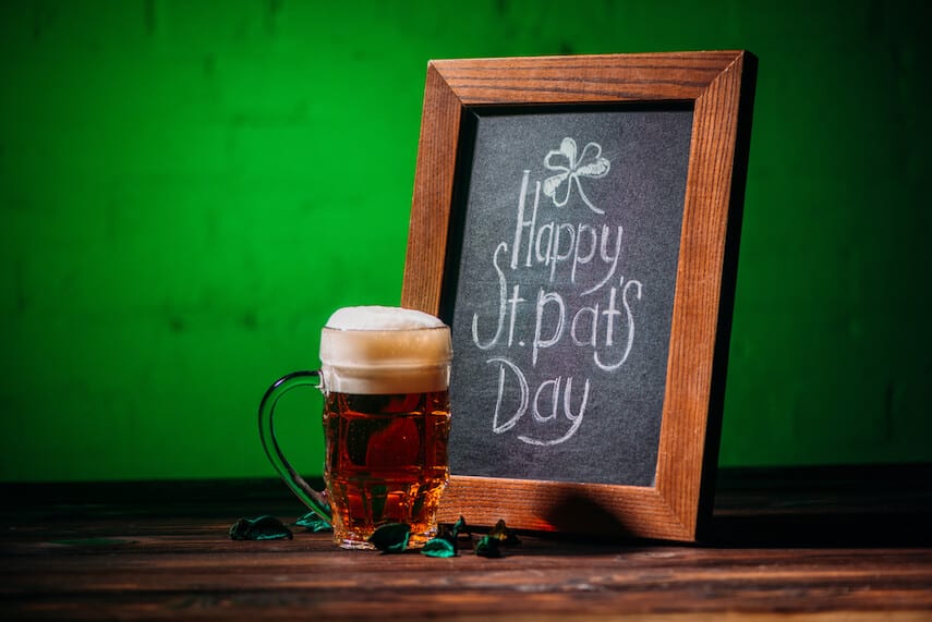 Happy St Pats Day written on a blackboard next to a pint of beer