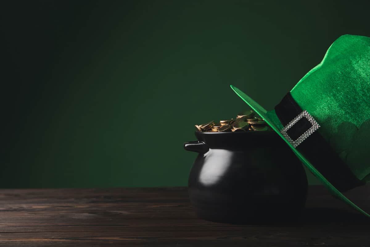 St Patricks Day Trivia Questions and Answers cover photo of a pot of gold with a green top hat leaning against it