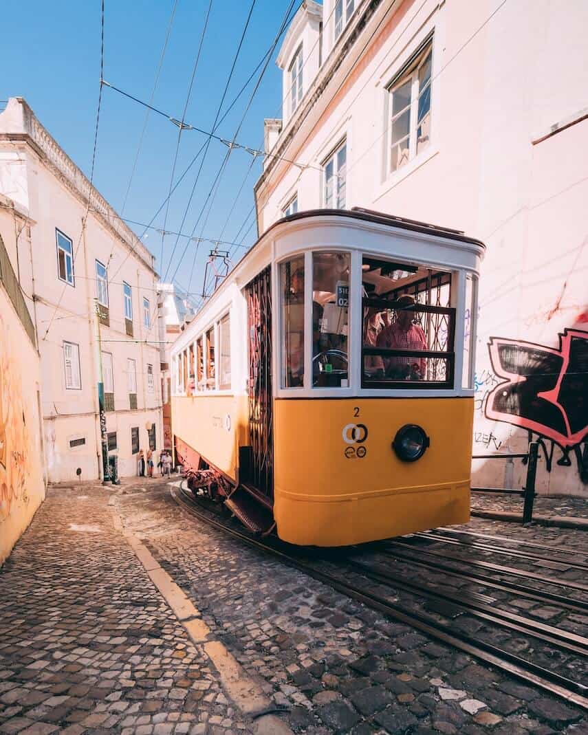 Yellow street car on cobbled street in Lisbon Portugal