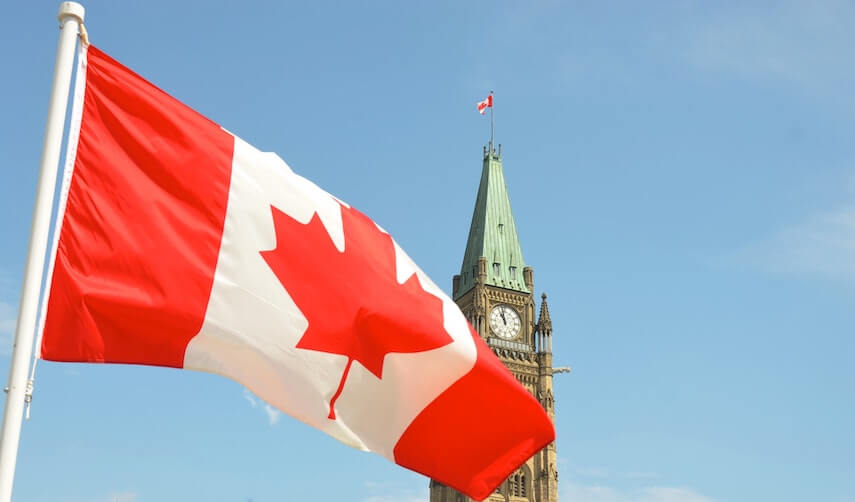 Canadian flag flying in front of a church spire