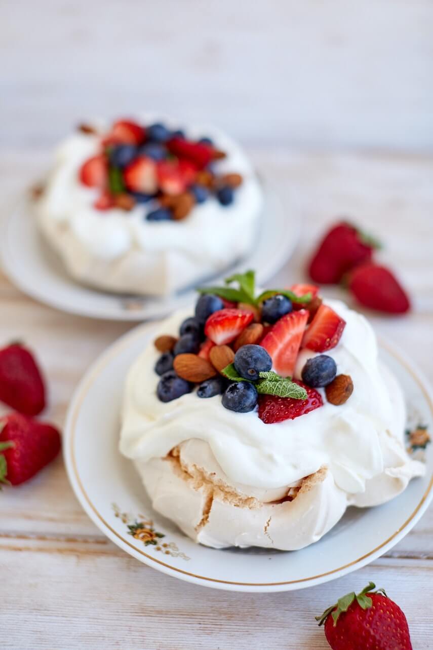 Pavlova topped with blueberries, strawberries and almonds