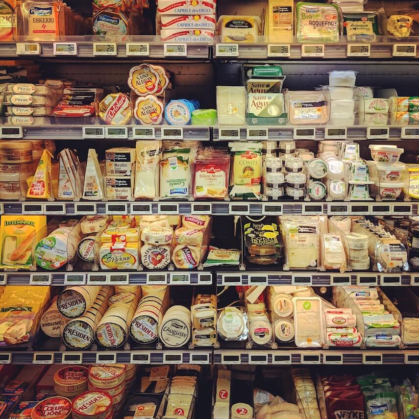 Supermarket display of cheeses on shelves