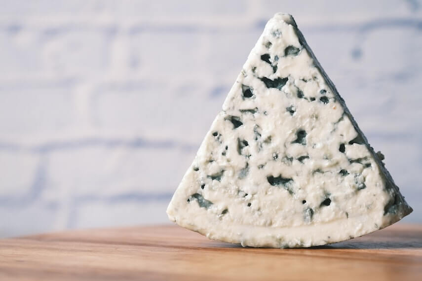Triangular wedge of blue cheese, point to the sky