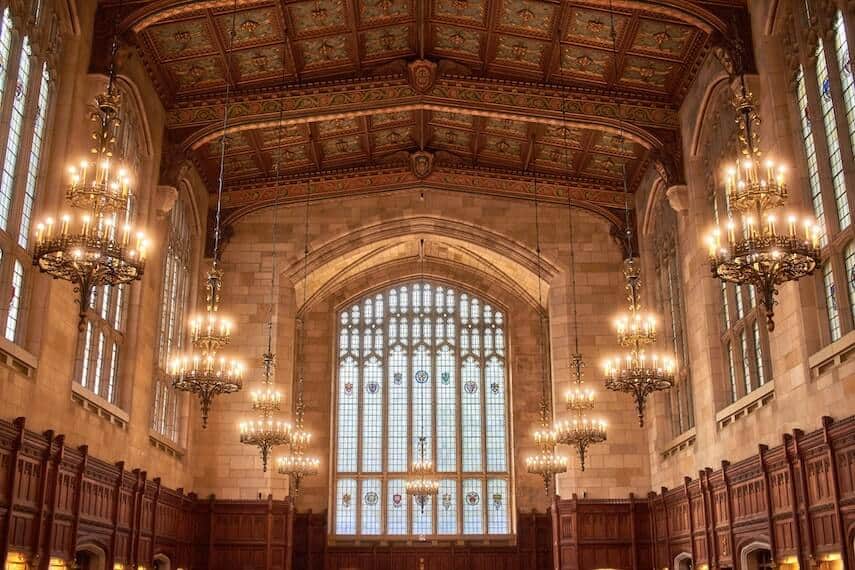 Vaulted ceiling and chandeliers surround by stained glass windows in The Great Hall
