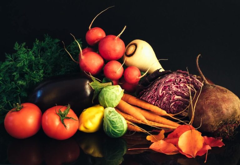 Vegetable Quiz Questions and Answers cover photo of multiple different vegetables laid out against a black background