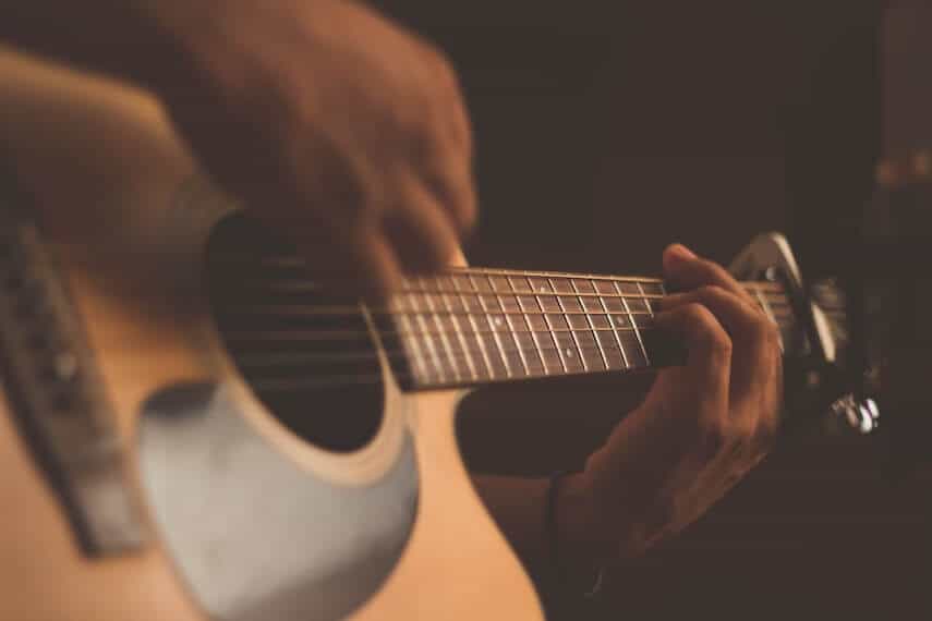 Close up of hands playing a guitar