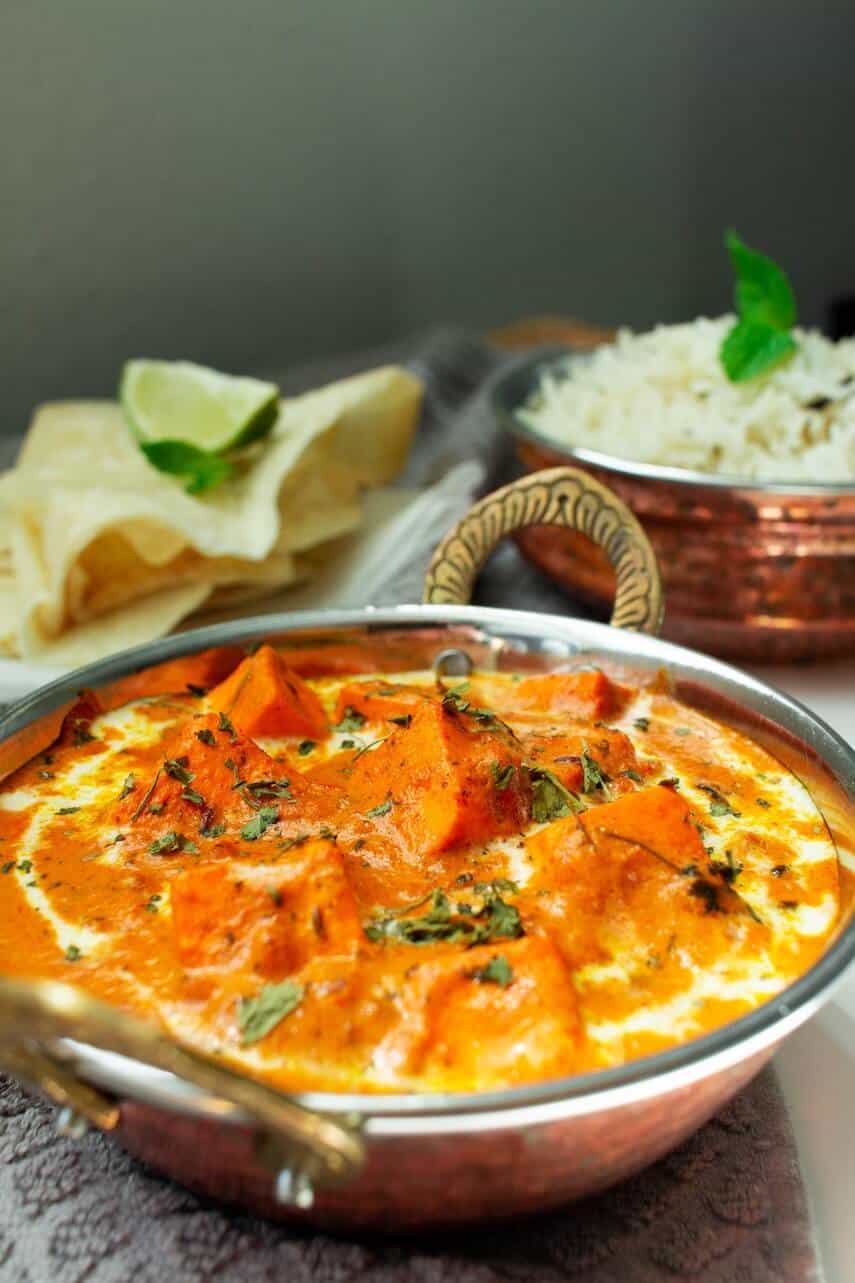 Curry and Rice in copper bowls with popadoms on the side