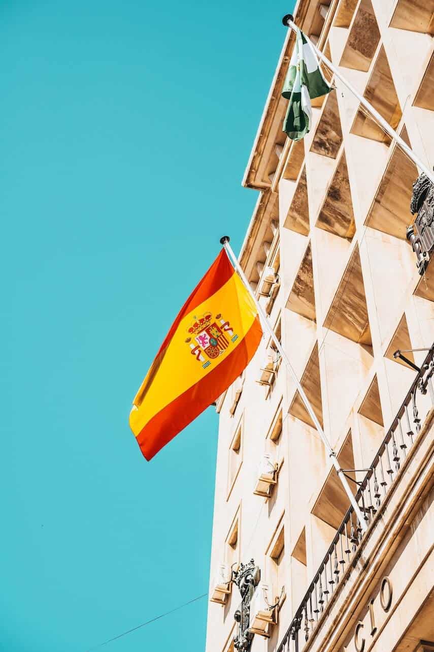 Spanish flag being flown on side of apartment building
