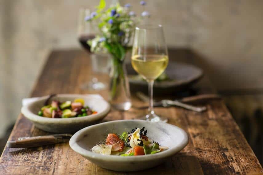 Table with two meals and a glass of red and white wine