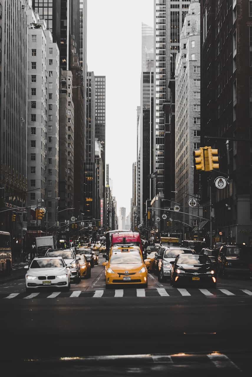 3 lanes of traffic driving towards the camera on a one way street in New York, a yellow taxi in the central lane