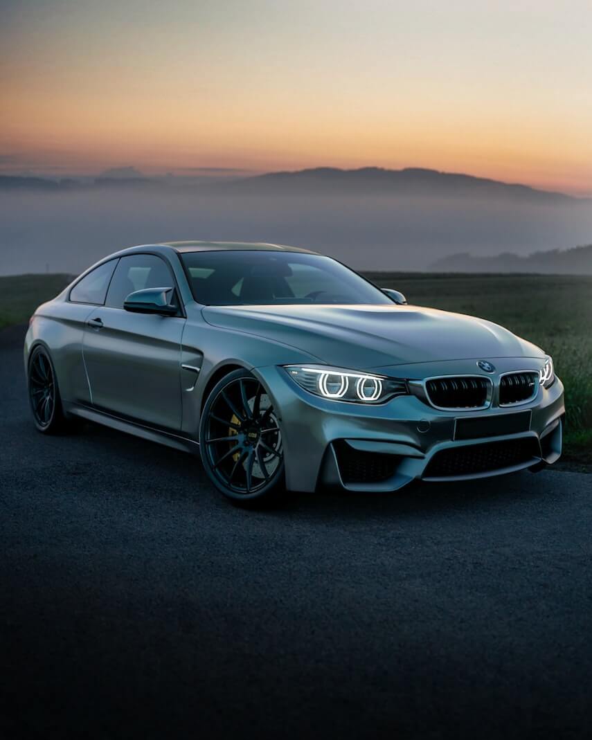 Silver BMW M4 at dawn in the mountains