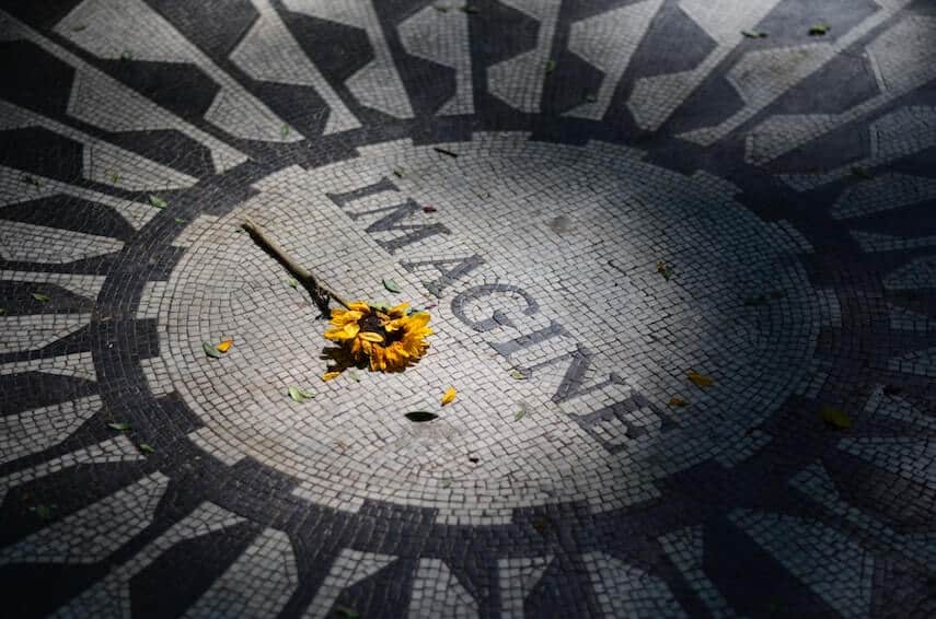 The Imagine mosaic mural at Strawberry Fields with a sunflower placed under the word