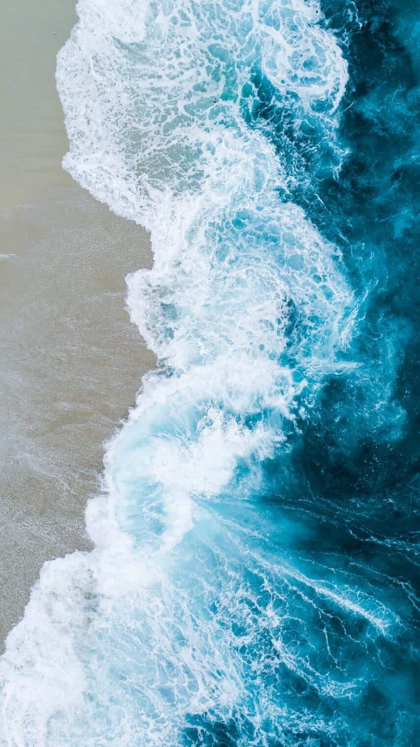 Top down shot of waves crashing on the sand