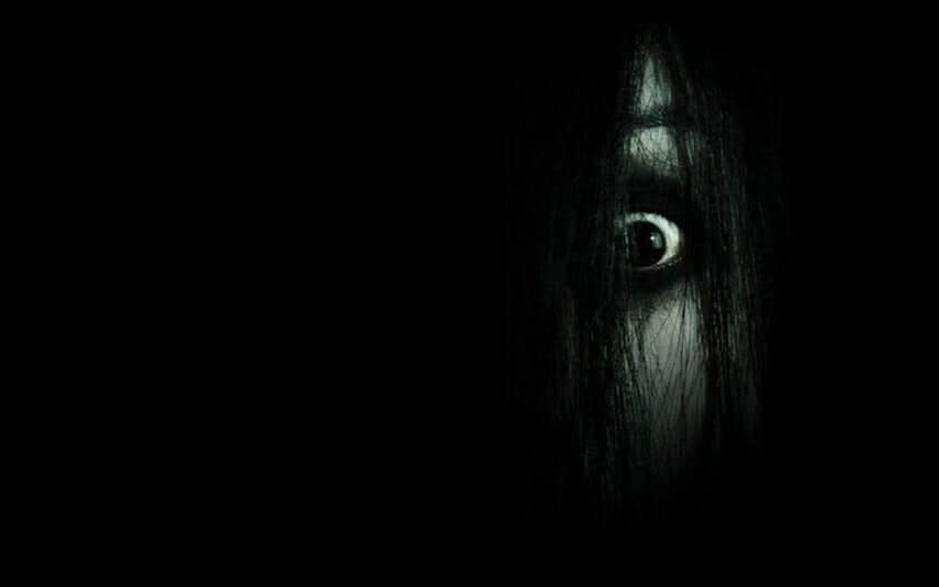 Creepy looking girls eye covered in long dark hair from 'The Grudge'