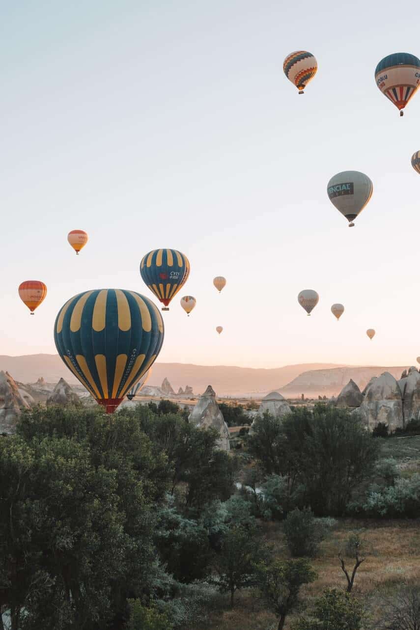 Hot air balloons flying over the jagged peaks of Cappadocia