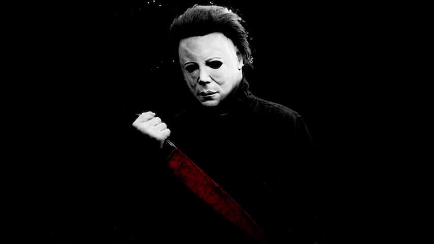 Michael Myers masked man holding a large blood covered knife