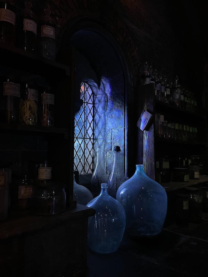 Old apothecary, shelves of glass concoctions and ingredients, a lead lined window in the middle of the shelves