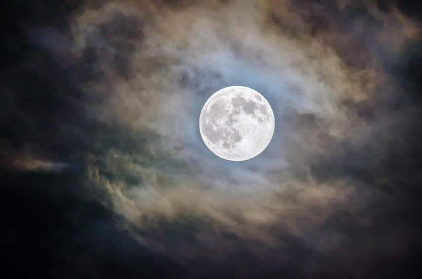 full moon surrounded by wispy clouds